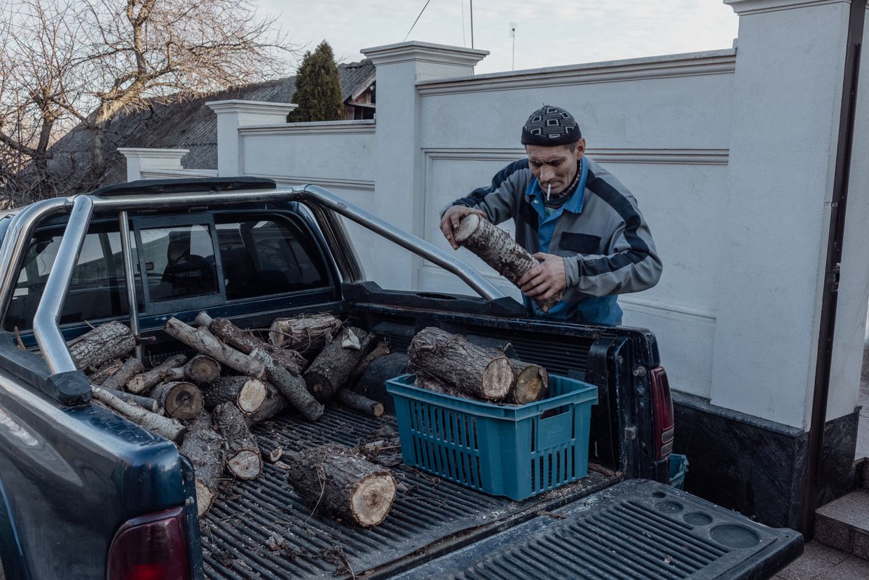 An employee of Tamara Cara delivers firewood to her home in Varniţa, Moldova on Jan. 8, 2025. 