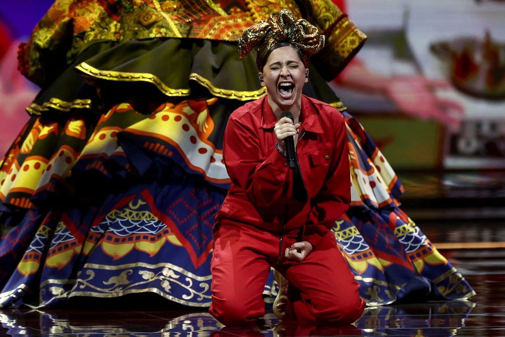 A Russian artist in a red jumpsuit performs onstage during the Eurovision contest 2021.