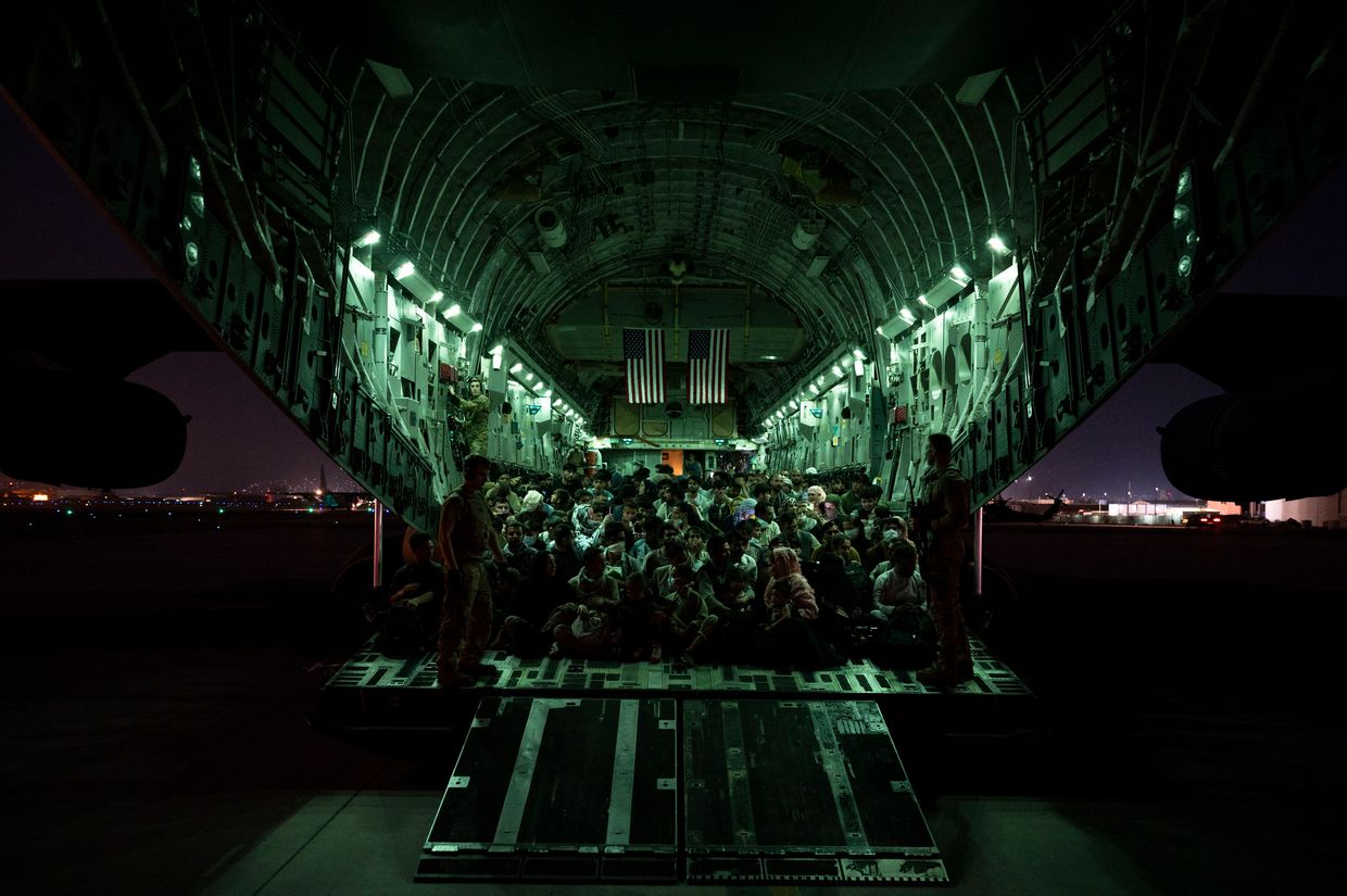 An air crew from the 816th Expeditionary Airlift Squadron assists evacuees aboard a C-17 at Hamid Karzai International Airport in Kabul, Afghanistan, on Aug. 21, 2021.