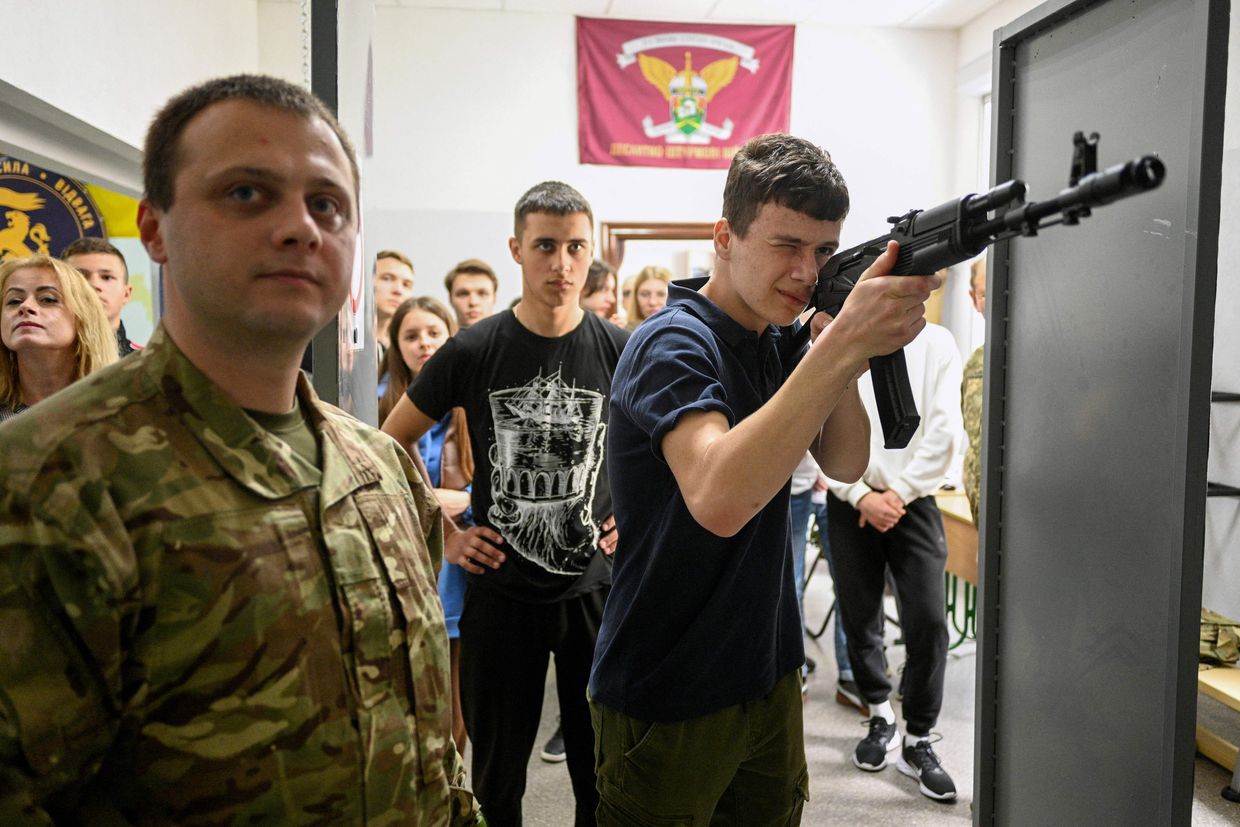 A boy uses a Kalashnikov AK47 rifle, during the "Defence of Ukraine" in Lviv, Ukraine, on May 17, 2023.