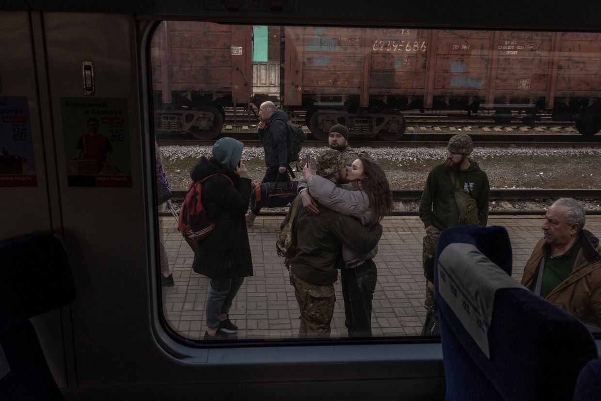 A Ukrainian serviceman kisses his partner upon arrival from Kyiv at a railway station in Sloviansk, Ukraine, on March 26, 2024.