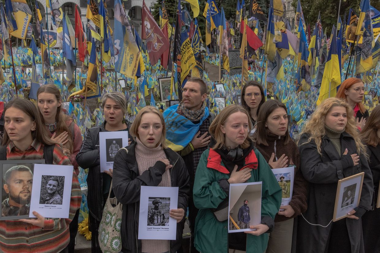 Attendees hold portrait placards and sing Ukraine’s national anthem during a moment of silence on Defenders Day in Kyiv, Ukraine, on Oct. 1, 2024. 