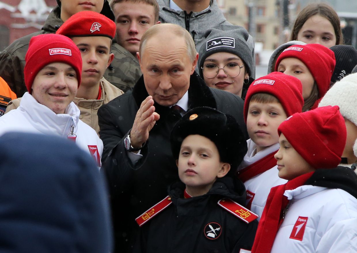 Russian President Vladimir Putin poses with children of Russian officers involved in the invasion of Ukraine and with members of the Youth Army and student organizations at Red Square, Moscow, Russia, on Nov.4, 2024.