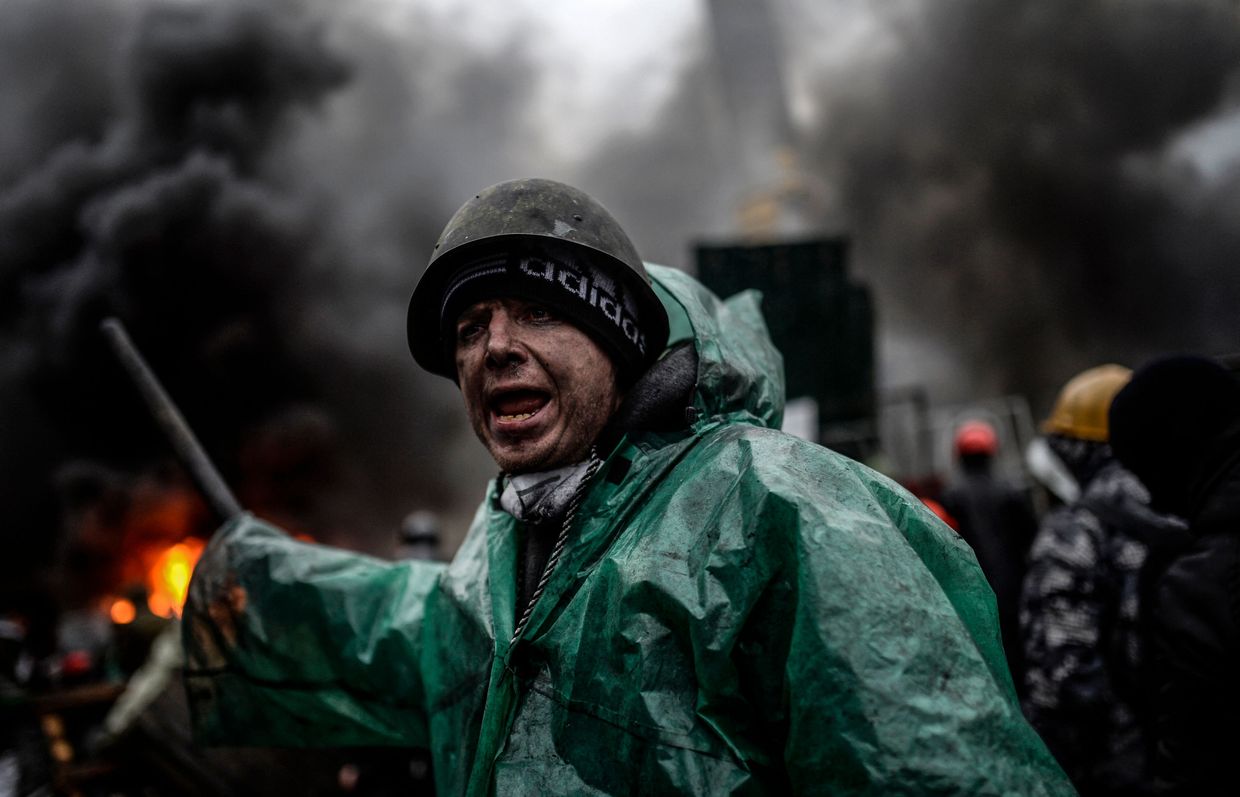 A protester stands behind barricades during clashes with police in Kyiv, Ukraine, on Feb. 20, 2014.