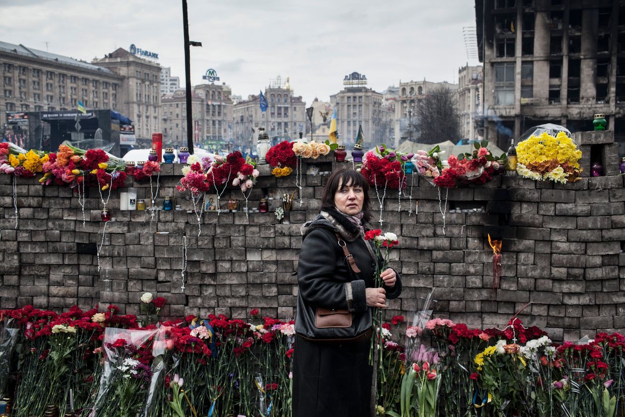 A woman lays carnations at a makeshift memorial for victims of recent riots on Instytutska Street in Kyiv, Ukraine, on Feb. 23, 2014. 