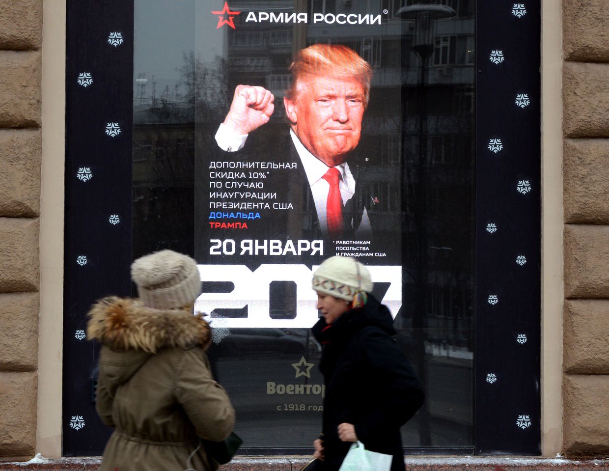 Women walk past a Voentorg military store ad featuring U.S. President-elect Donald Trump in central Moscow, Russia on Jan. 19, 2017. 