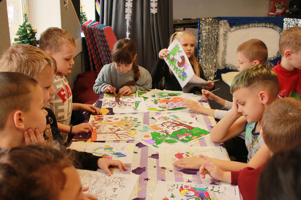 Schoolchildren look at their drawings during a break between lessons in Druzhkivka, Ukraine on Dec. 16, 2024. 