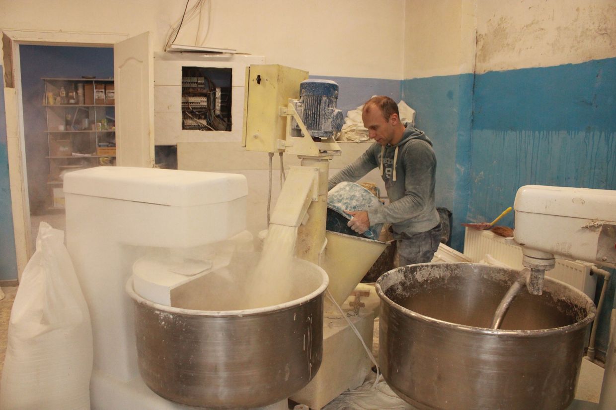 A bakery worker sifts flour to bake bread in Druzhkivka, Ukraine on Dec. 16, 2024.