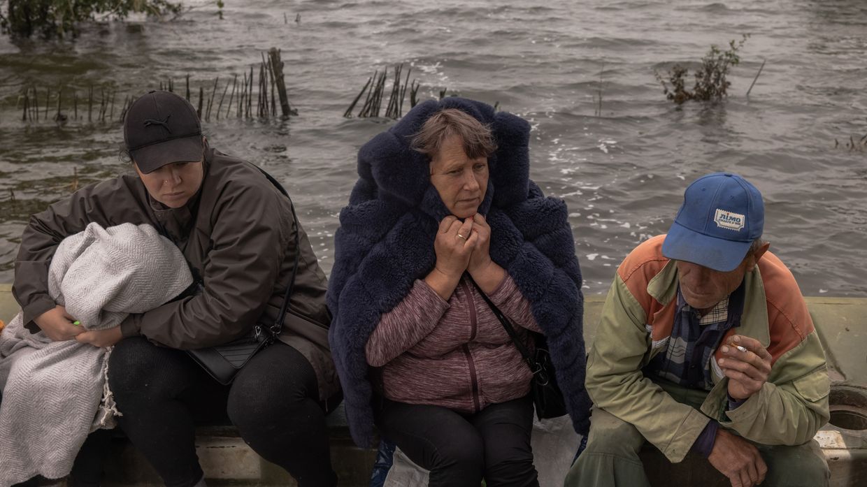 People wait for a transfer on a pontoon in a flooded area in Afanasiivka, Mykolaiv Oblast, Ukraine on June 12, 2023