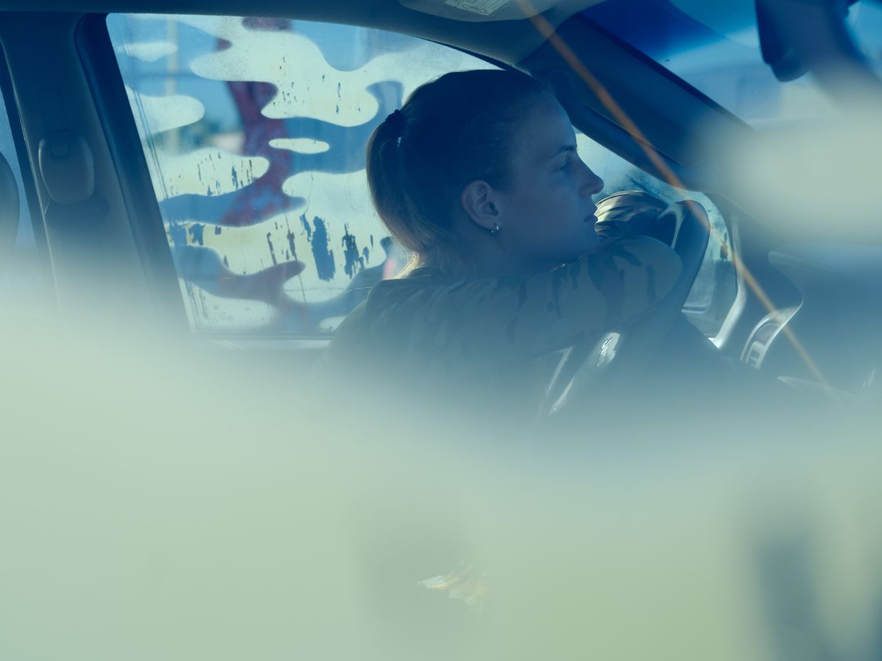 Oksana resting in her car after a trip to her unit's positions, Kupiansk, Kharkiv Oblast, Ukraine, in Aug. 2024.