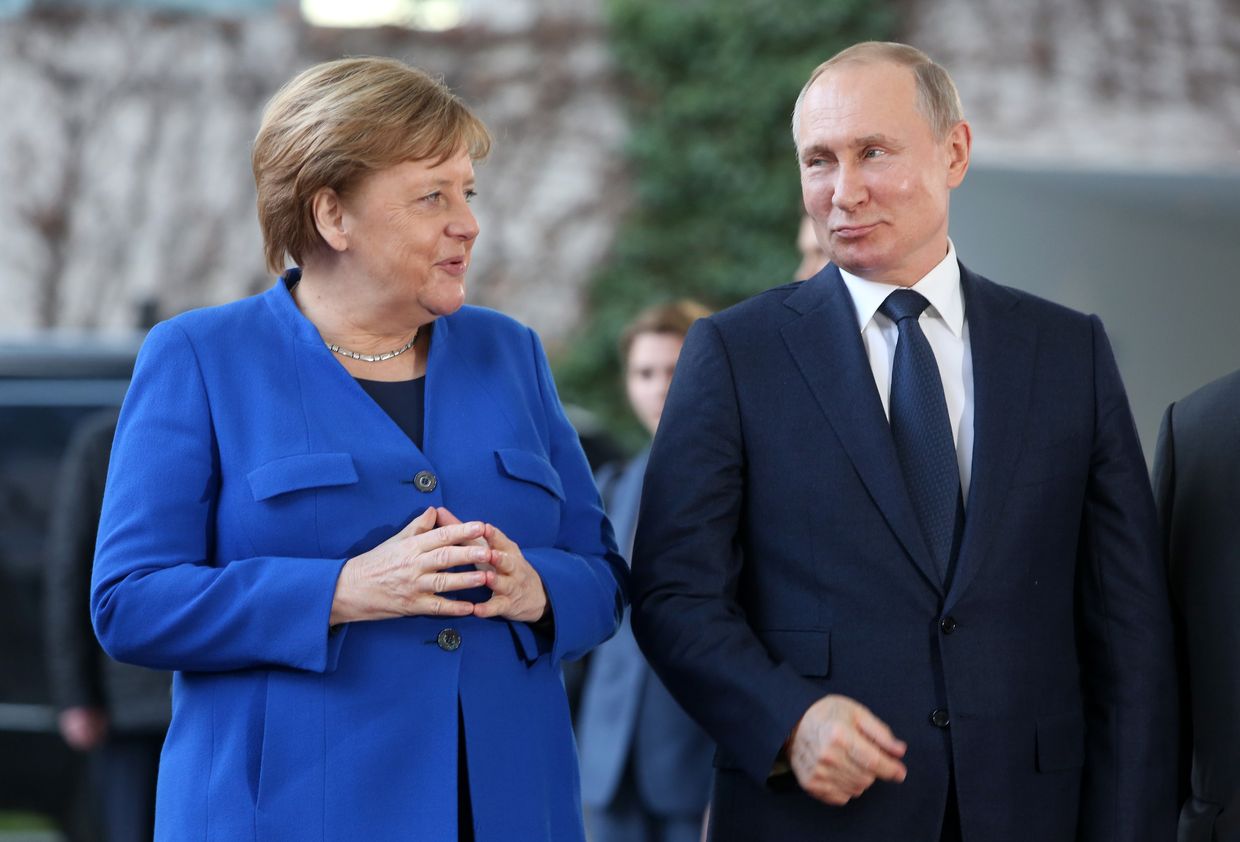 German then-Chancellor Angela Merkel greets Russian President Vladimir Putin at a summit on Libya at the German Chancellery in Berlin, Germany, on Jan. 19, 2020. 