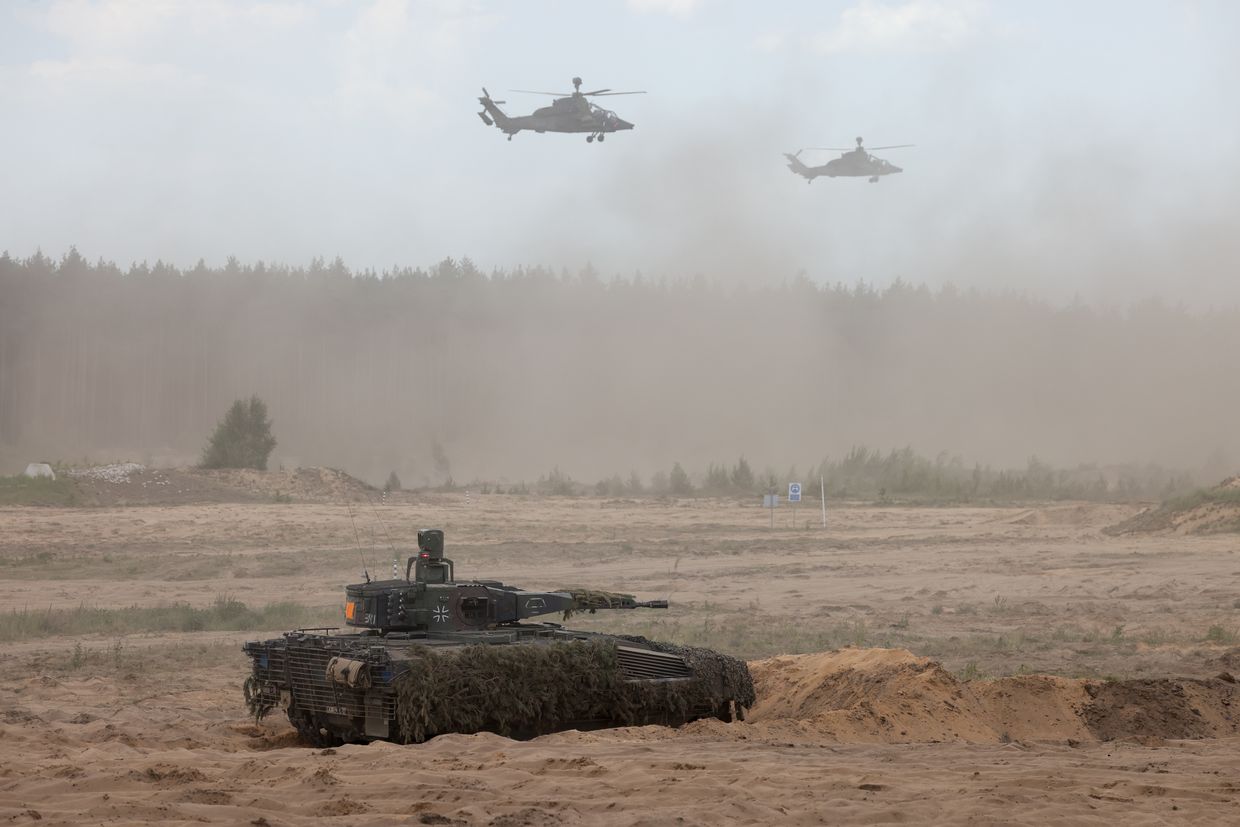 Tiger attack helicopters fly near a German Army Puma infantry fighting vehicle during the NATO Quadriga exercise in Pabrade, Lithuania, on May 29, 2024. 