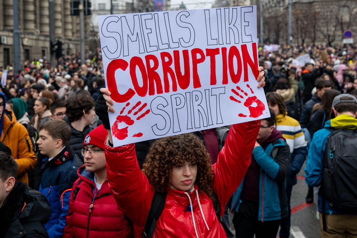 A woman holds a placard reading "Smells like corruption spirit" during a demonstration in Belgrade, Serbia, on Jan. 24, 2025. 