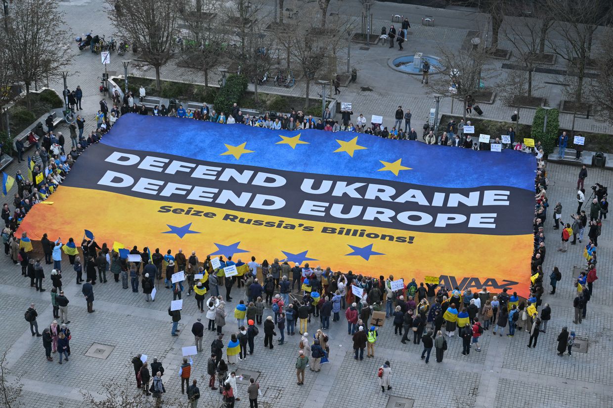  flag reading "Defend Ukraine, Defend Europe" in Brussels, Belgium, on March 5, 2025.