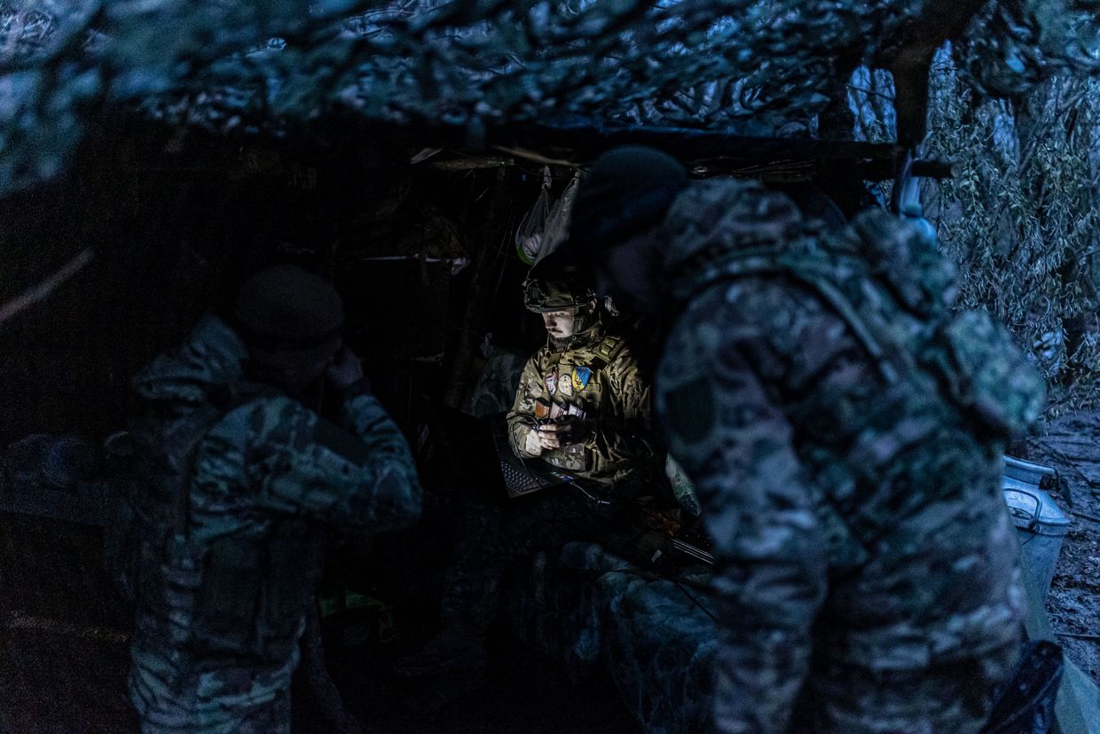 A Ukrainian soldier uses a computer next to a shelter at a frontline position near Bakhmut, Donetsk Oblast, Ukraine, on Nov. 18, 2023.