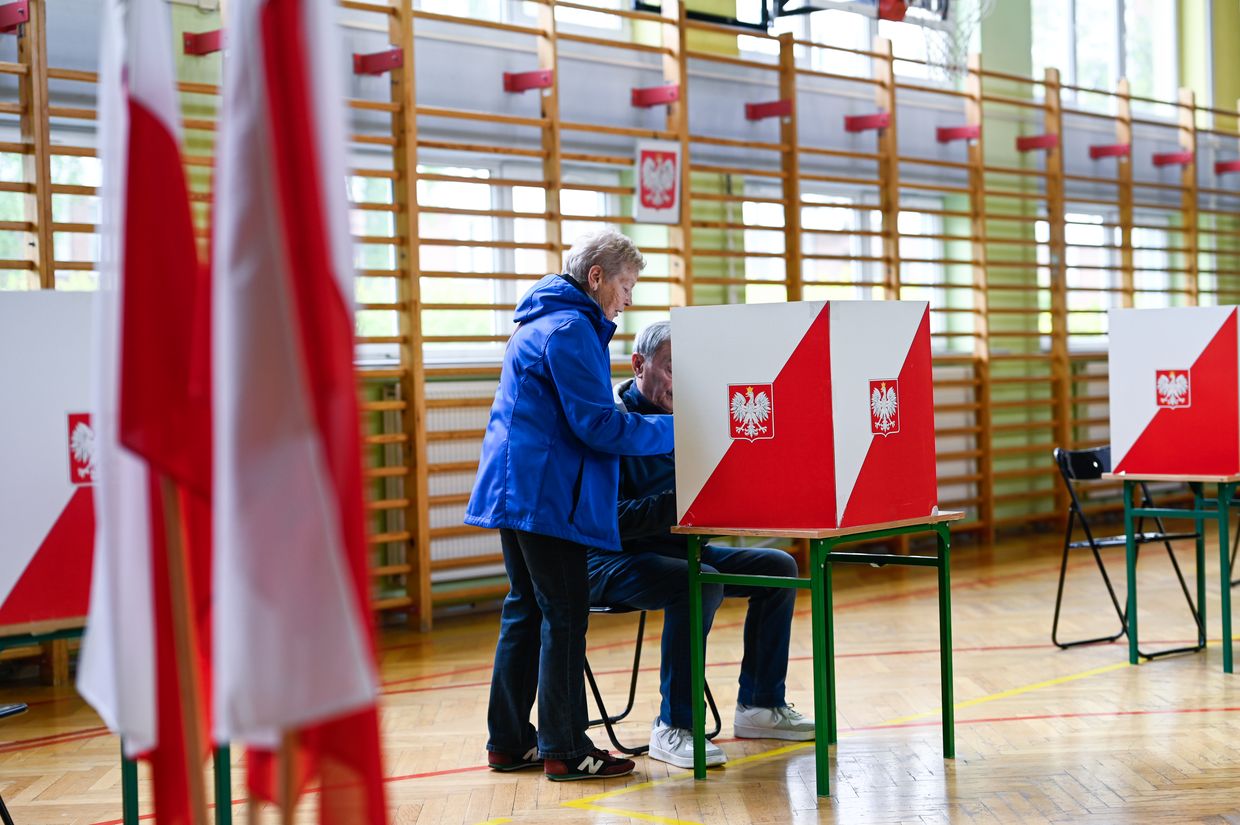 An elderly couple vote during the first round of Poland’s presidential election in Warsaw on May 18, 2025.