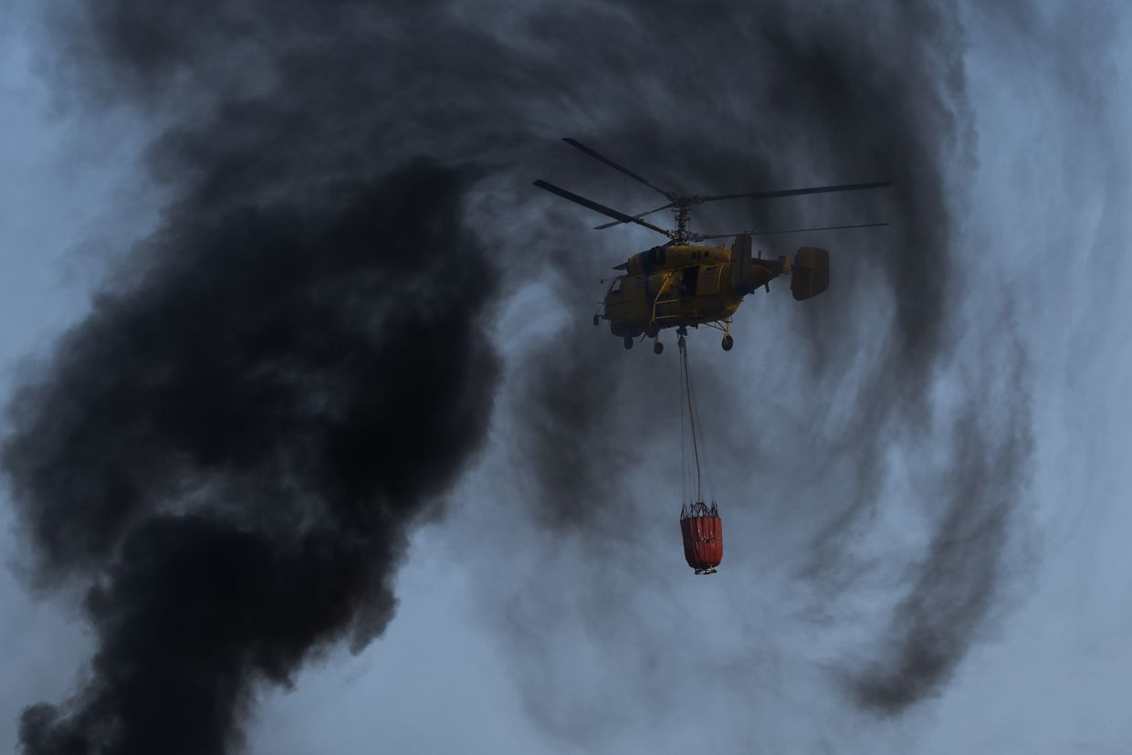 A Ka-32 helicopter extinguishes a fire after a Russian combined attack in Kyiv, Ukraine, on June 25, 2025.