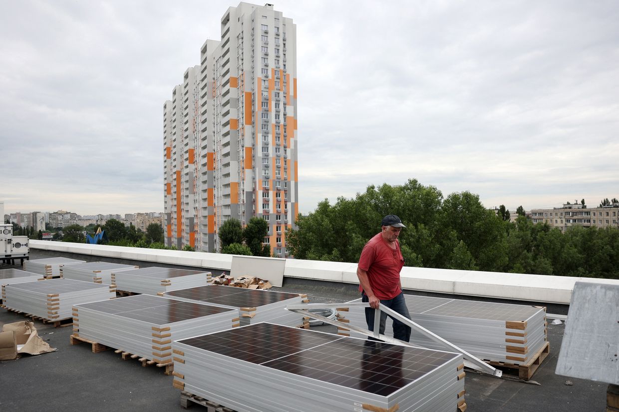 A worker installs solar panels in Kyiv, Ukraine on June 14, 2024. (Anatolii Stepanov / AFP via Getty Images)