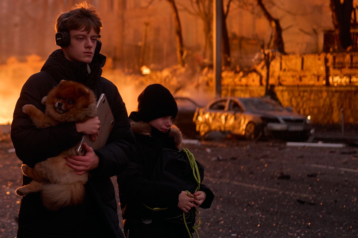 Civilians carry a dog after a Russian ballistic missile strike on the city center in Kyiv, Ukraine, on Dec. 20, 2024.