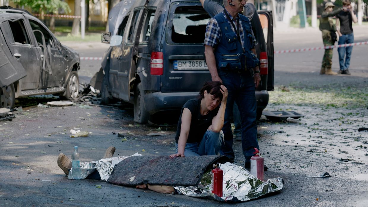 A woman mourns next to a body after a Russian multiple rocket attack on Sumy, Ukraine, on June 3, 2025. 