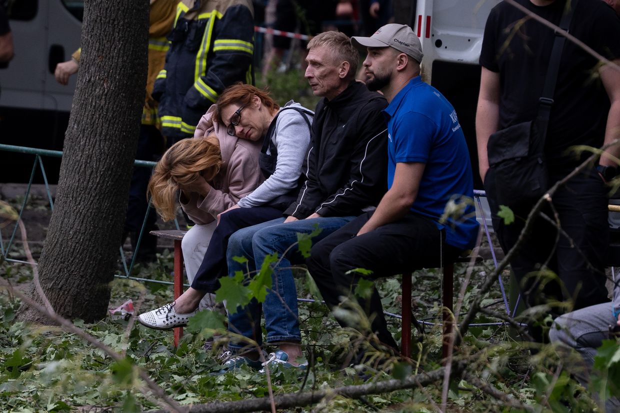 Parents wait while rescuers search for their missing son in the rubble of a partially collapsed residential building after a Russian drone-and-missile attack in Kyiv, Ukraine, on June 17, 2025.