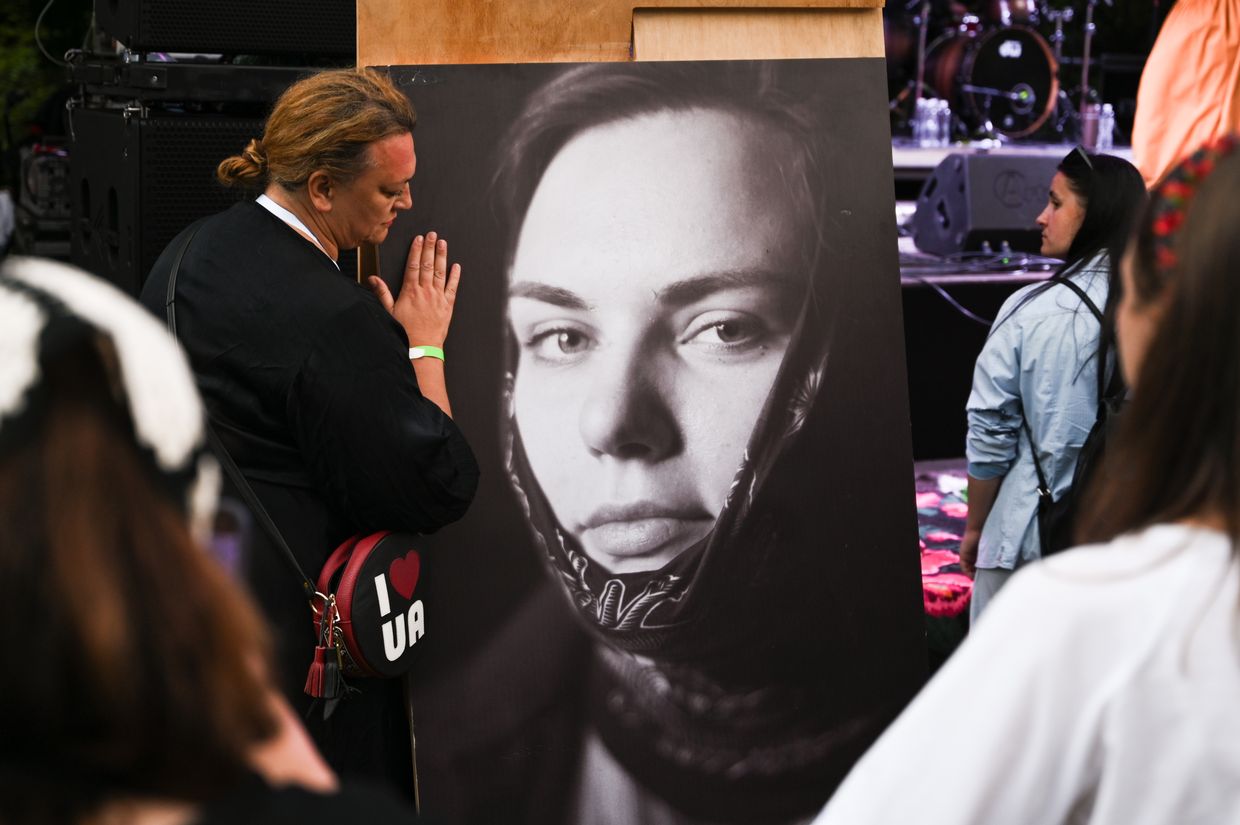 Librarian Tetiana Pylypets, 50, hugs a photo of fallen combat medic Iryna “Cheka” Tsybukh during ChekaFest in Lviv, Ukraine, on June 1, 2025.
