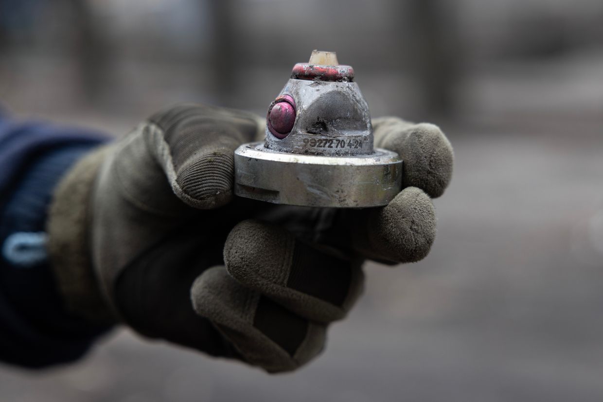 A Ukrainian deminer team with the Department of State Emergency Service shows a cluster bomb fragment after a large-scale Russian attack on a residential complex in Dobropillia, Ukraine, on March 10, 2025. 