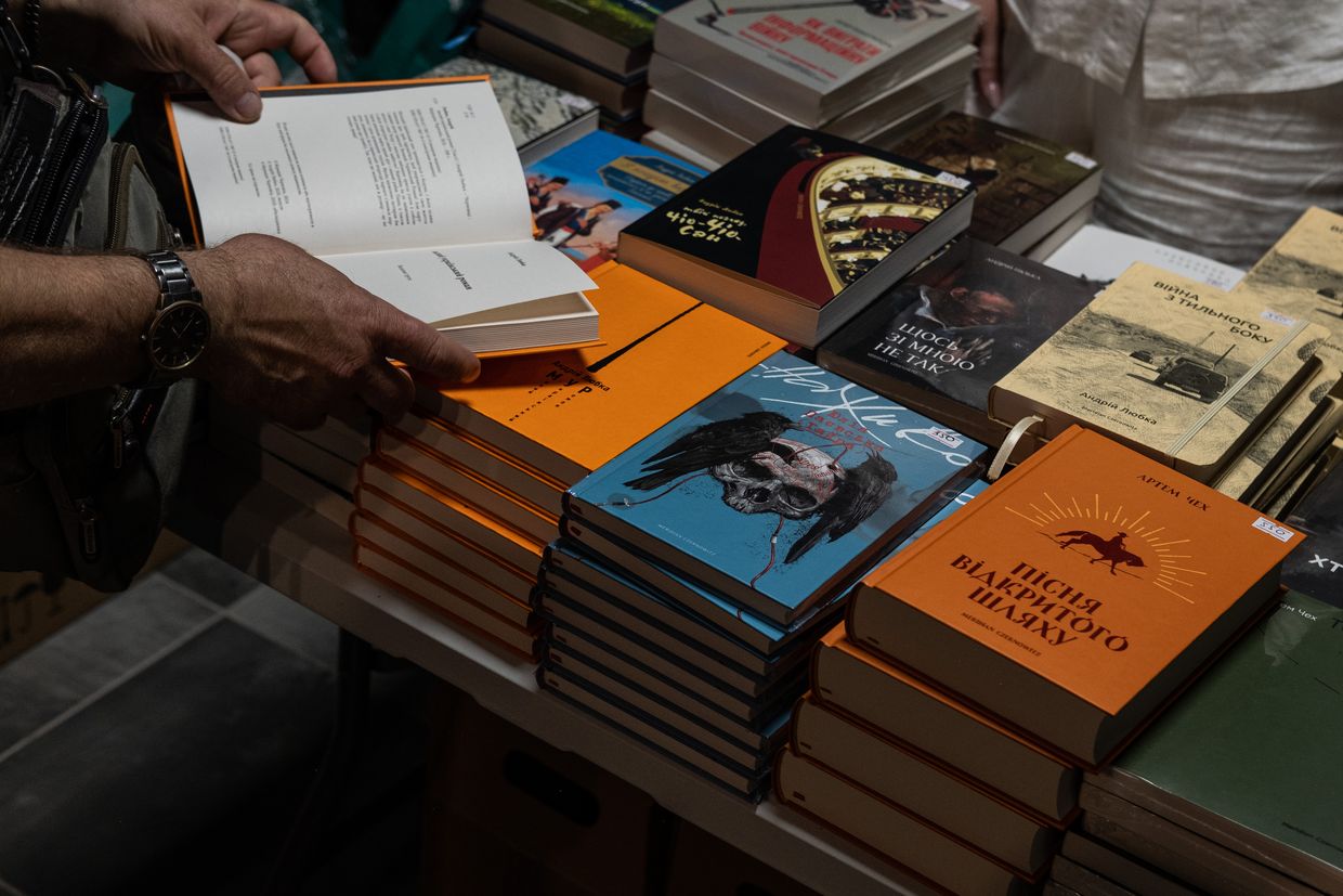 An attendee browses books by Ukrainian authors and poets during the Meridian Czernowitz literary festival in Zaporizhzhia, Ukraine, on June 29, 2025.