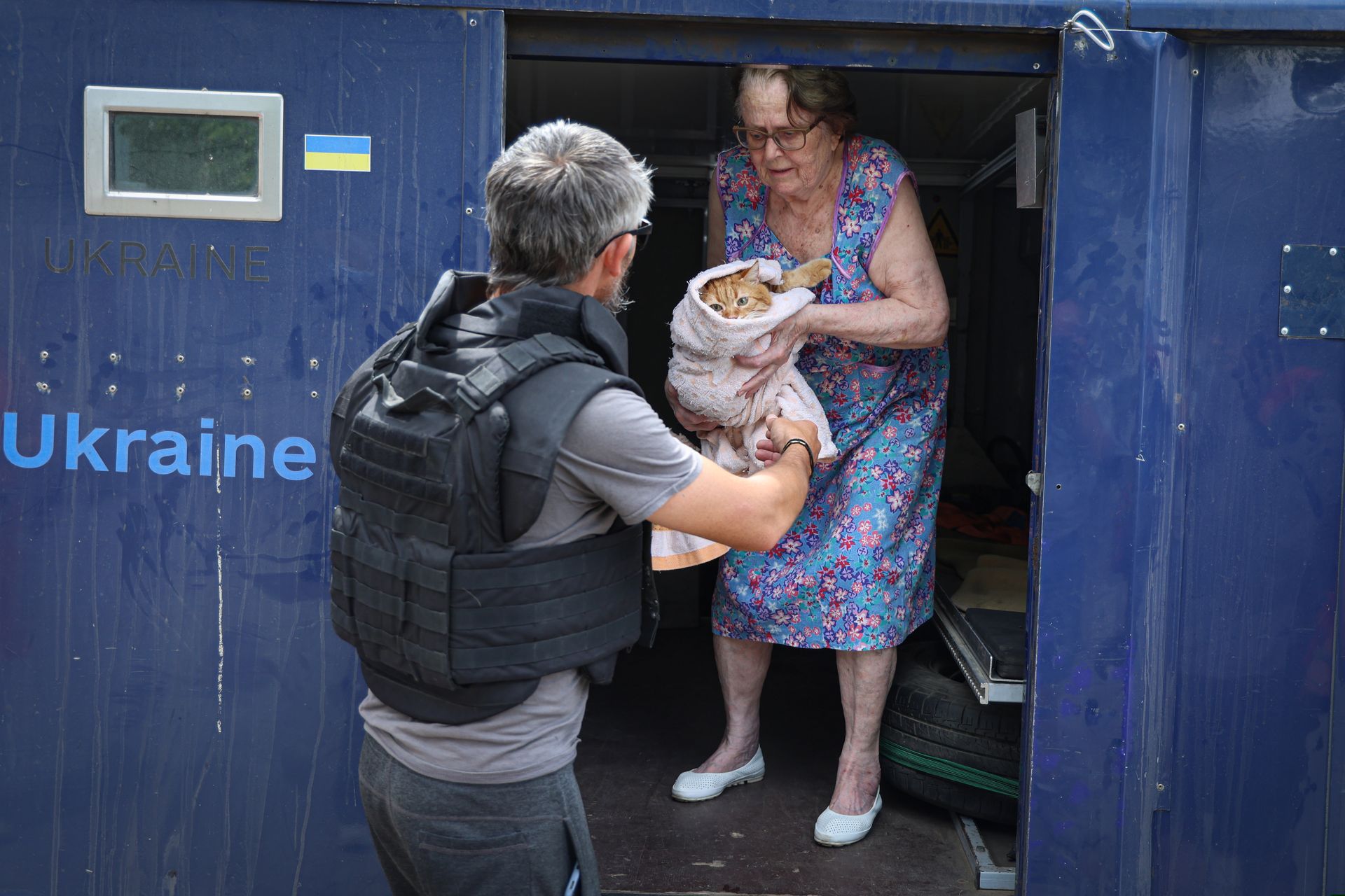 Volunteer helps a local resident with a cat during the evacuation in Kherson, Ukraine, on Aug. 4, 2025.