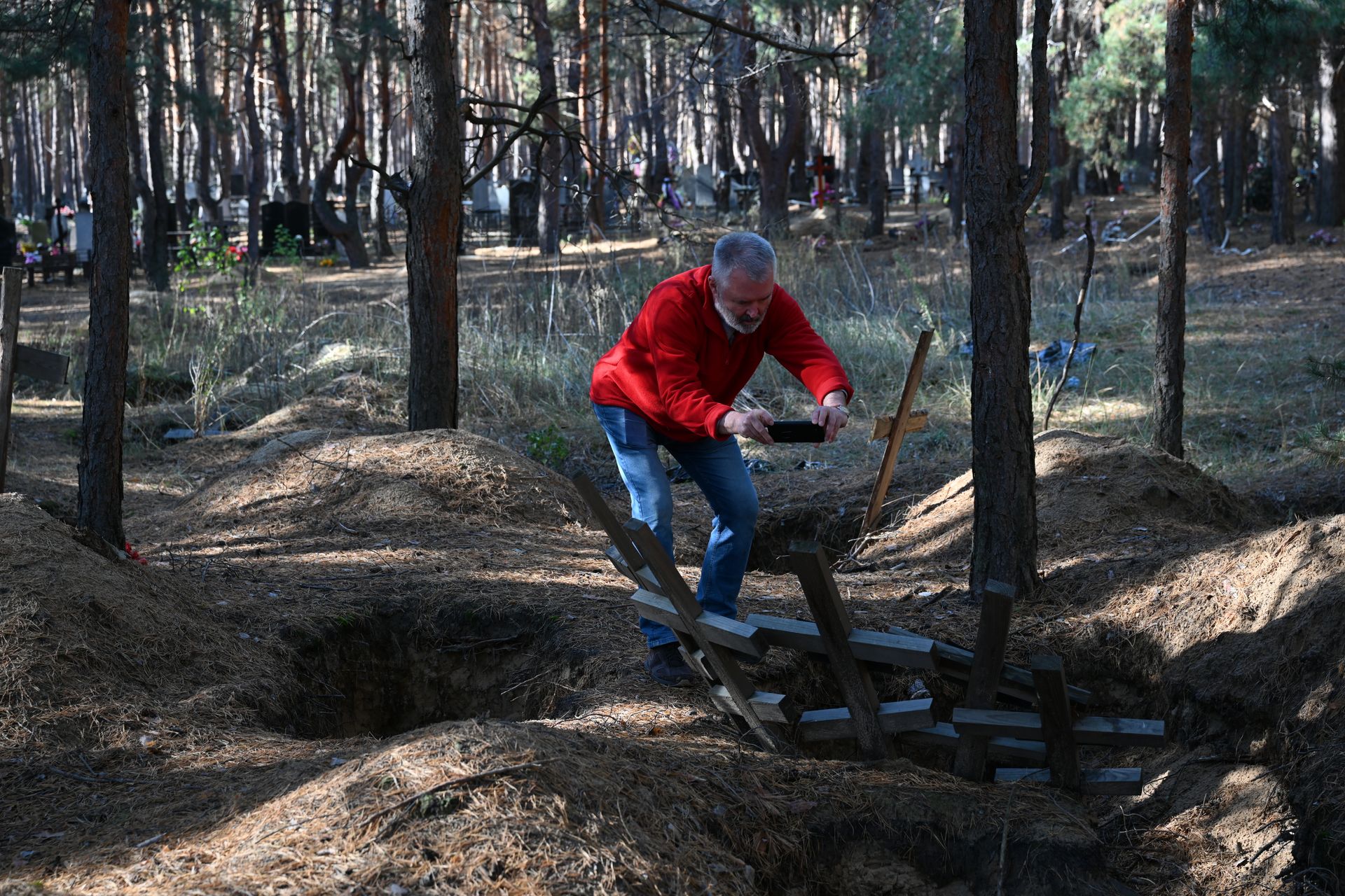 Ivo takes pictures of a mass grave site in Izium, Ukraine, Kharkiv Oblast, in October 2024.