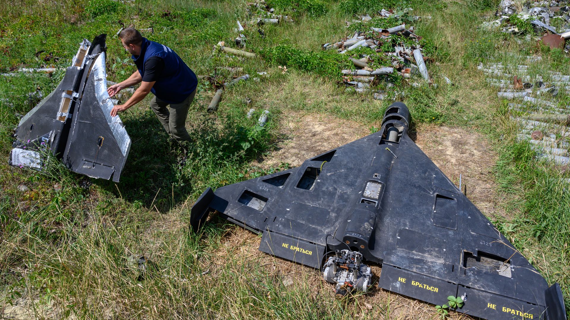 A person holds the remains of a Russian-made decoy drone, known as a Gerbera, beside an Iran-designed Shahed-136 drone, or Geran-2, in Kharkiv, Ukraine, on July 30, 2025.