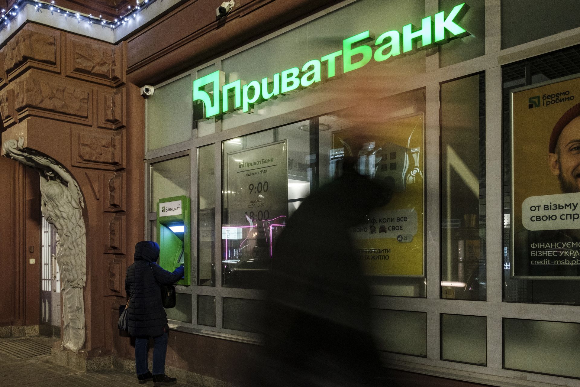 A customer uses an ATM at a PrivatBank branch in Kyiv, Ukraine, on Feb. 22, 2022. 