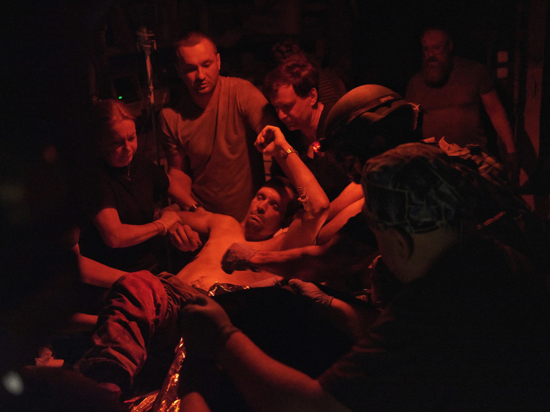 A team of medics from the 4th Separate Battalion helps a seriously wounded soldier at a stabilization point after evacuation from the front lines.