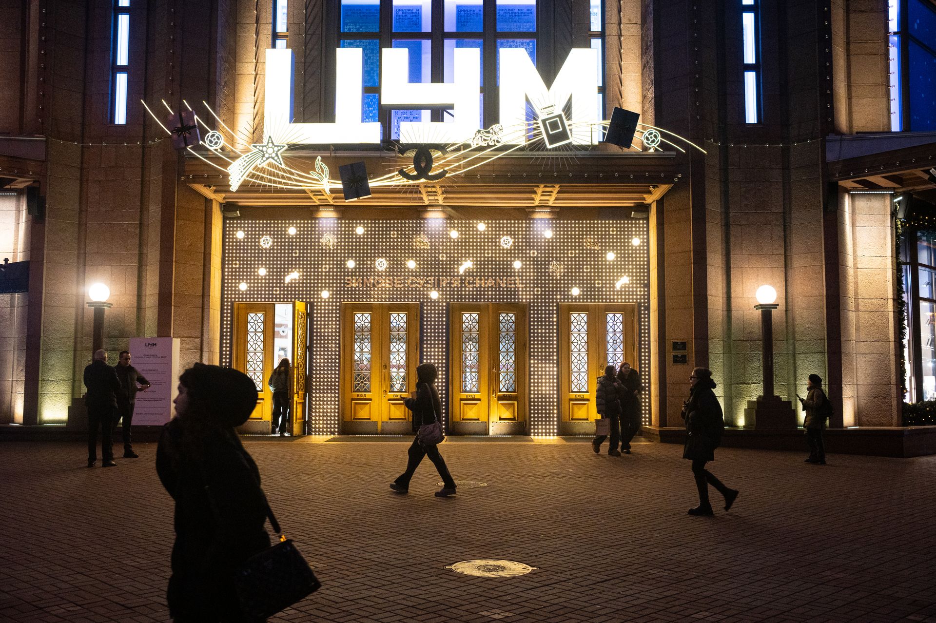 People walk past the TSUM department store illuminated with festive lights in central Kyiv, Ukraine, on Dec. 17, 2025