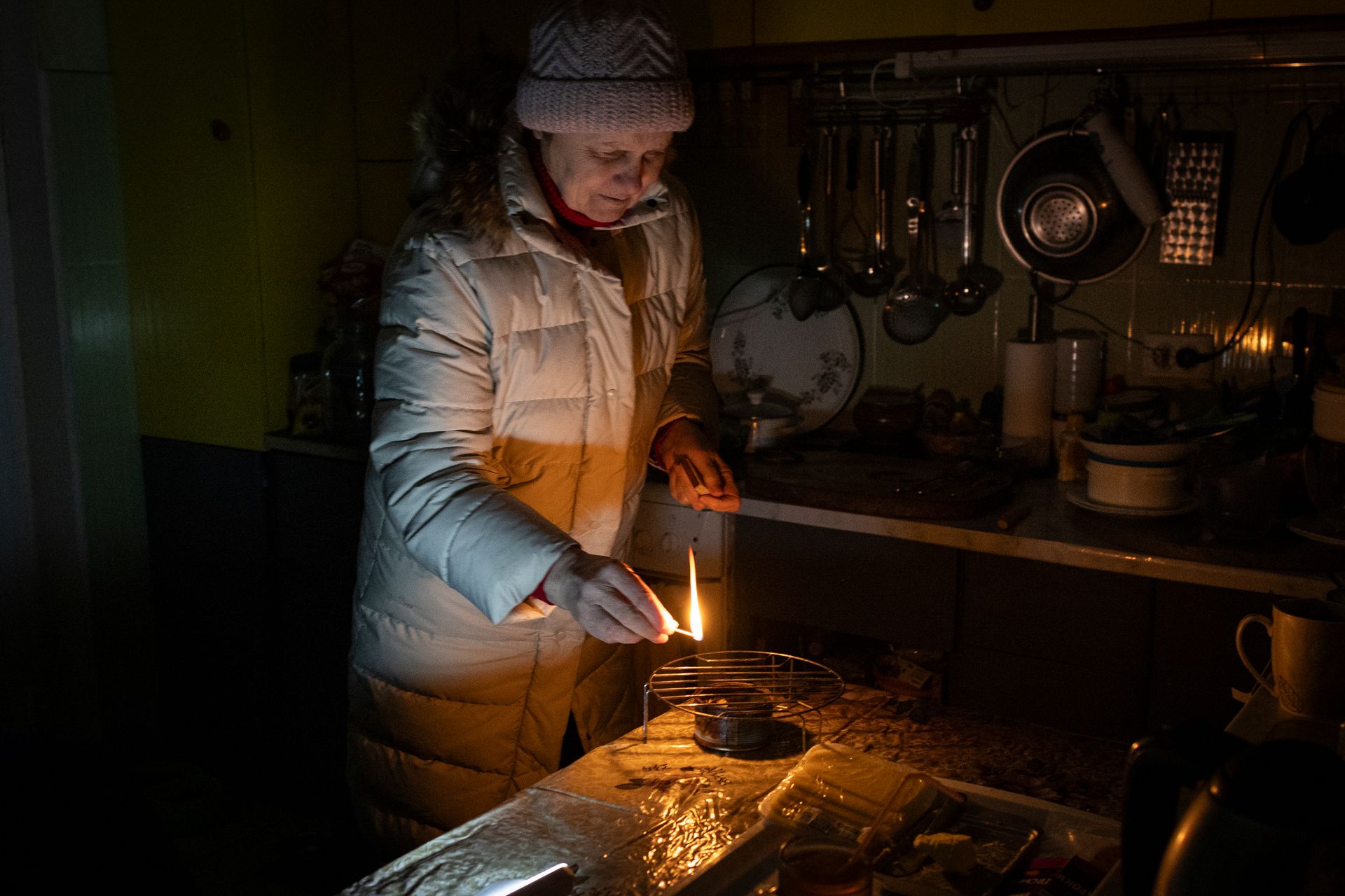 Raisa Donbekirova, 65, lights an alcohol “trench candle,” the only source of heat in her apartment, left without water, electricity, and heating after strikes on critical infrastructure in Kyiv, Ukraine, on Jan. 10, 2026. 