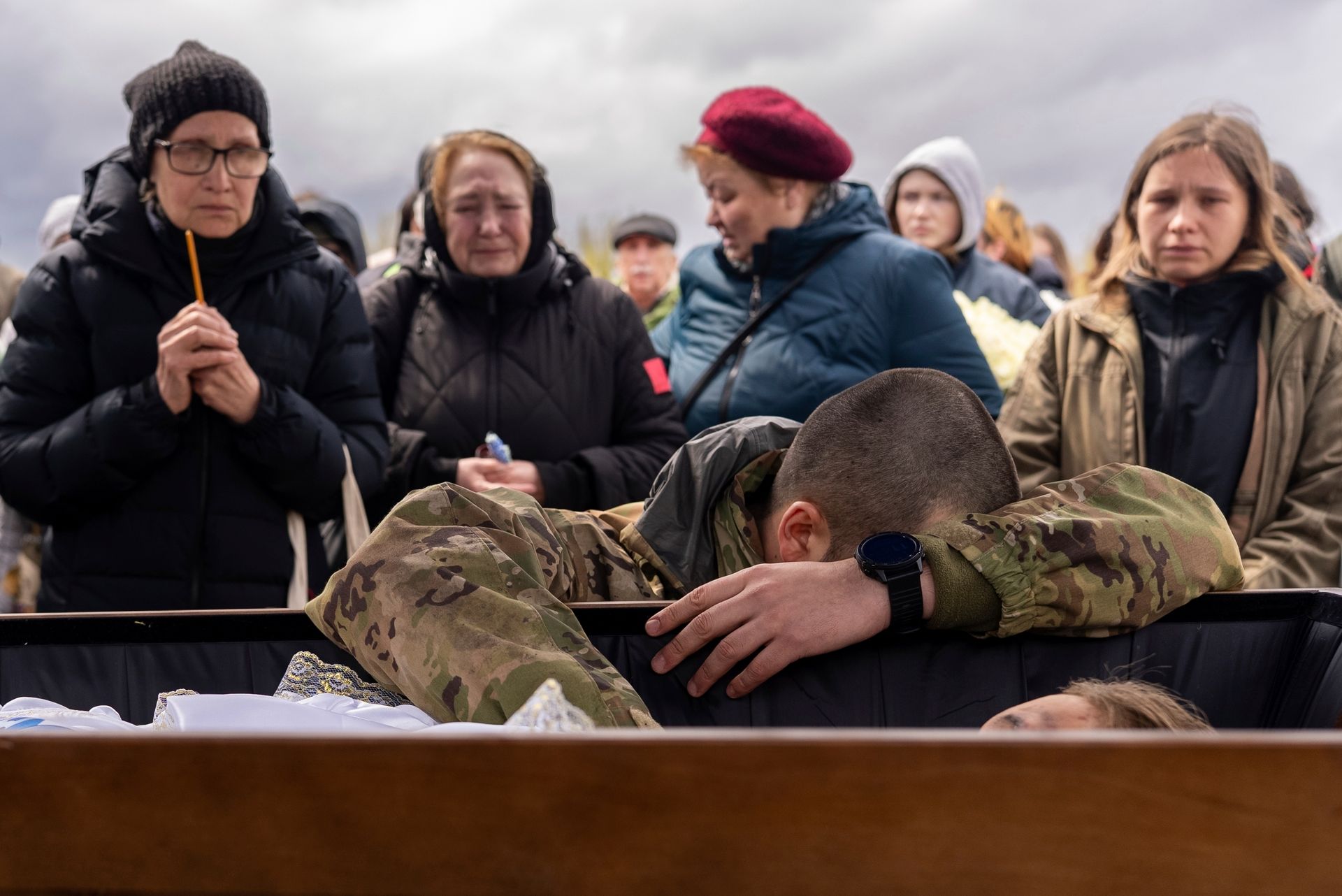 A fellow serviceman mourns over the coffin of Marharyta Polovinko, 31, a Ukrainian artist, paramedic and volunteer in Kryvyi Rih, Ukraine, on April 11, 2025. 