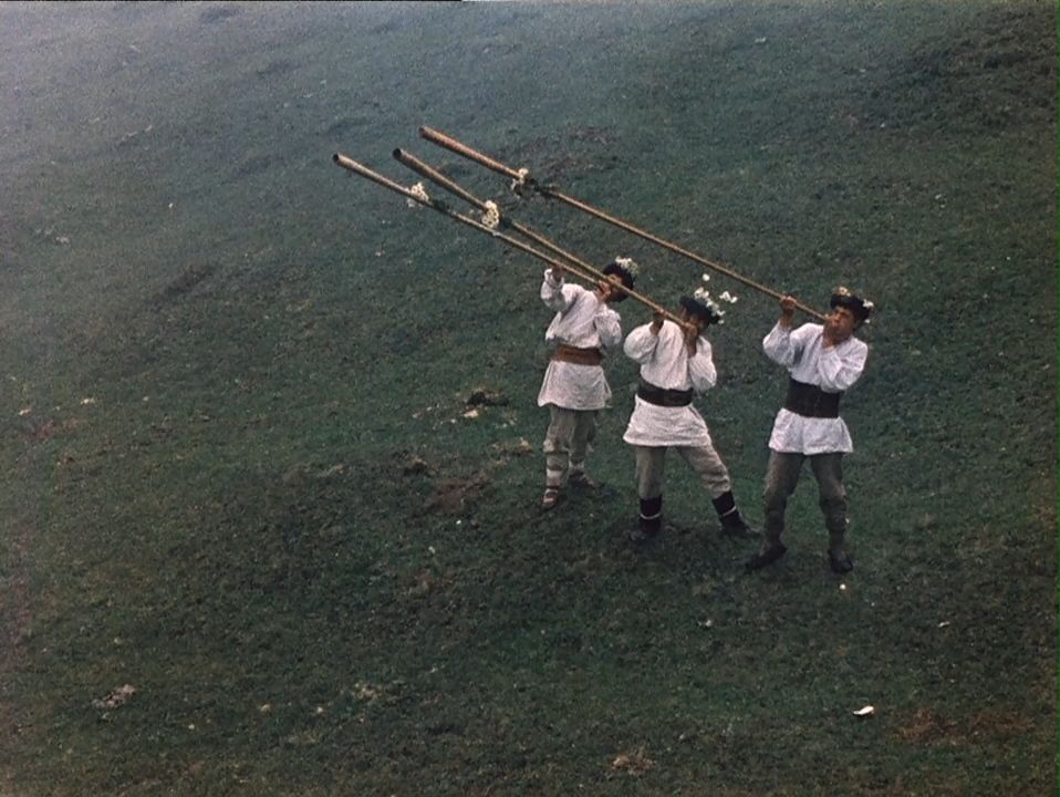 A screen grab from Shadows of Forgotten Ancestors (1965) shows three Hutsuls playing trembitas.