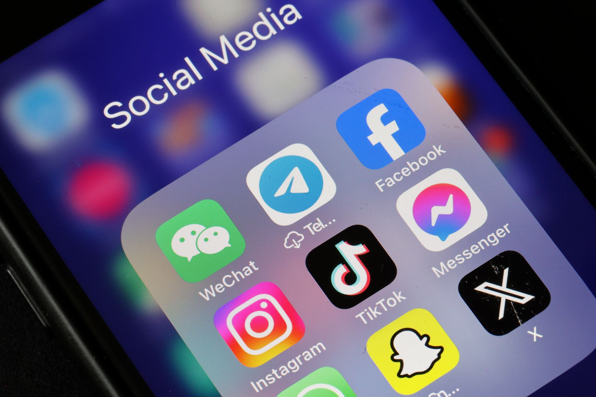 WeChat, Telegram, Facebook, Instagram, TikTok, Messenger, Snapchat, and X application logos are displayed on an iPhone's screen.