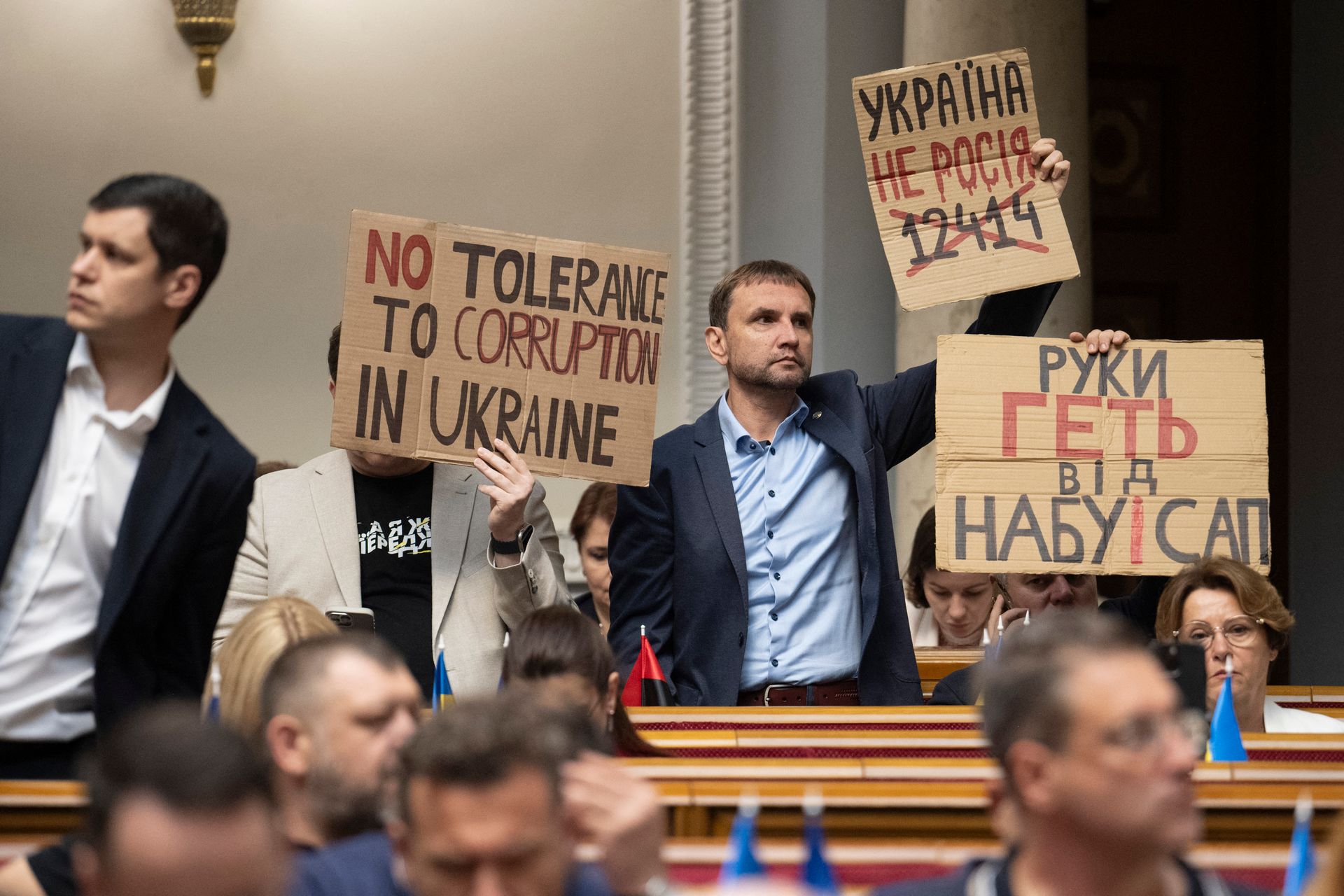 Ukrainian lawmakers protest with placards as they vote on a bill to restore the powers of anti-corruption institutions at the Verkhovna Rada in Kyiv, Ukraine, on July 31, 2025.