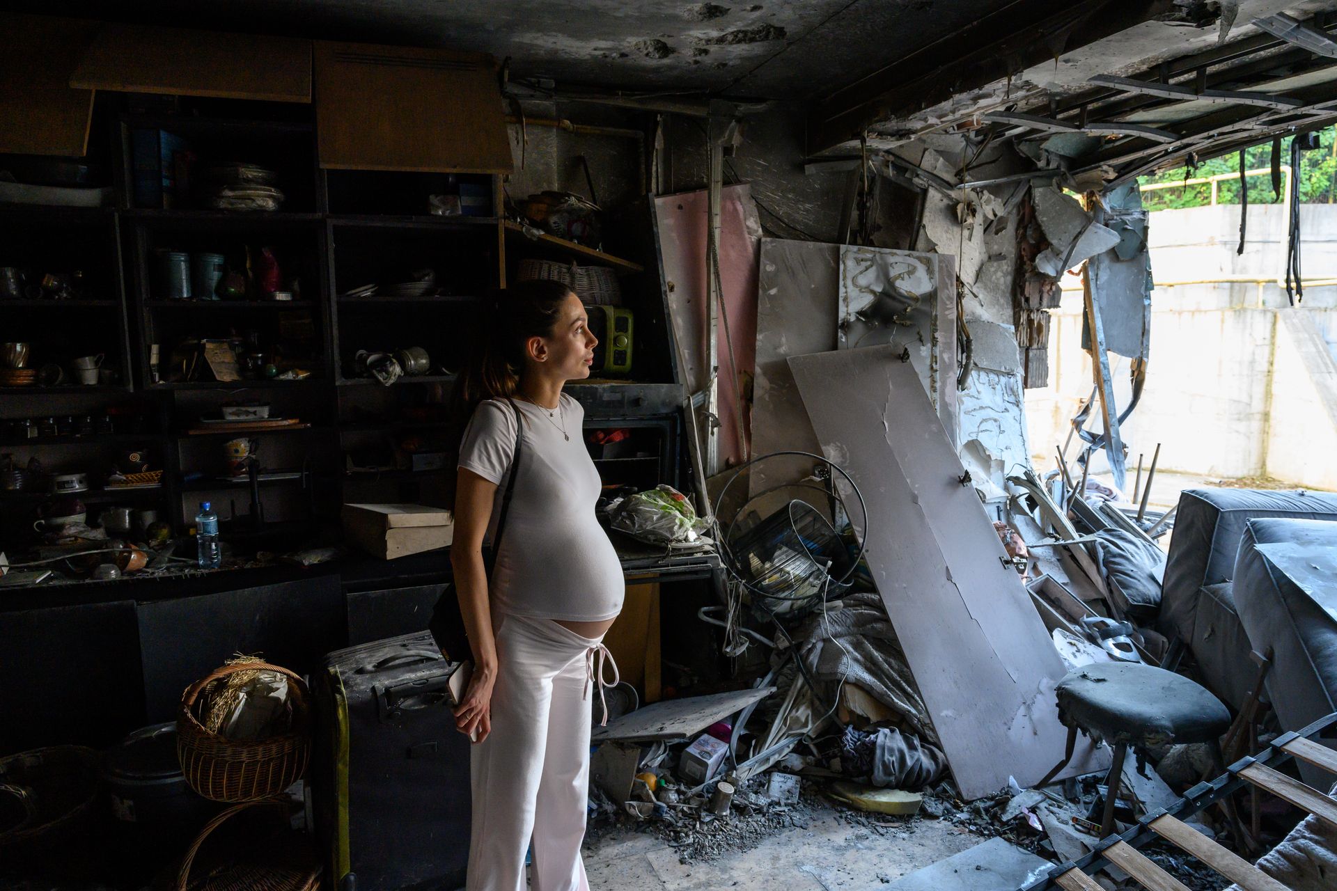 Ukrainian Bogdana Zhupanyna, in her ninth month of pregnancy, surveys damage to her apartment after it was struck by a Russian-made, Iran-designed Shahed-136 drone in Kharkiv, Ukraine, on July 23, 2025. 