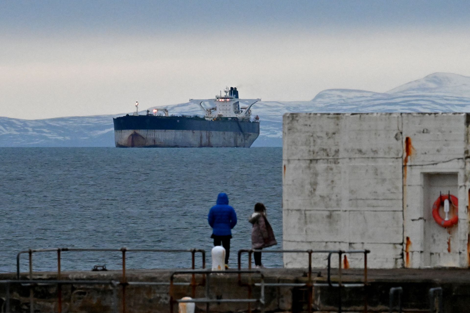 People look out at the oil tanker Marinera, formerly known as the Bella-1, from Hopeman Harbour in the Moray Firth, Scotland, United Kingdom, on Jan. 14, 2026.