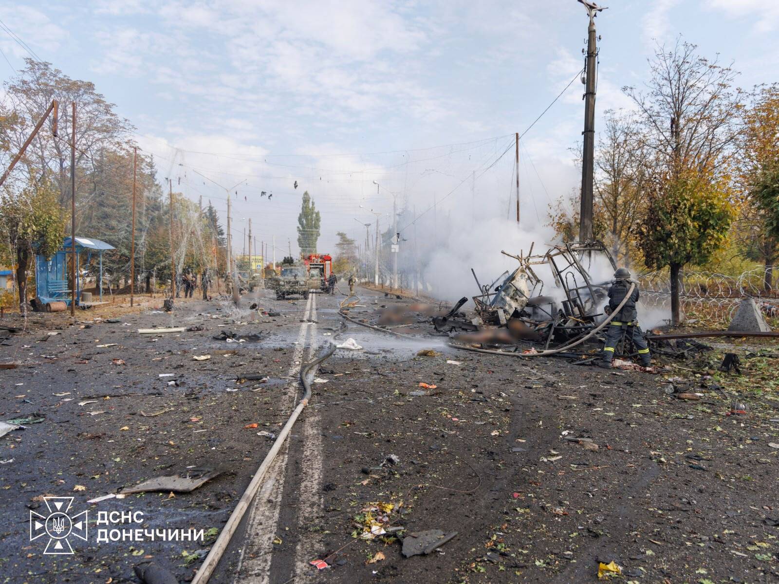 Firefighters work around a burned-out passenger bus after a Russian glide bomb strike in Kramatorsk, Ukraine